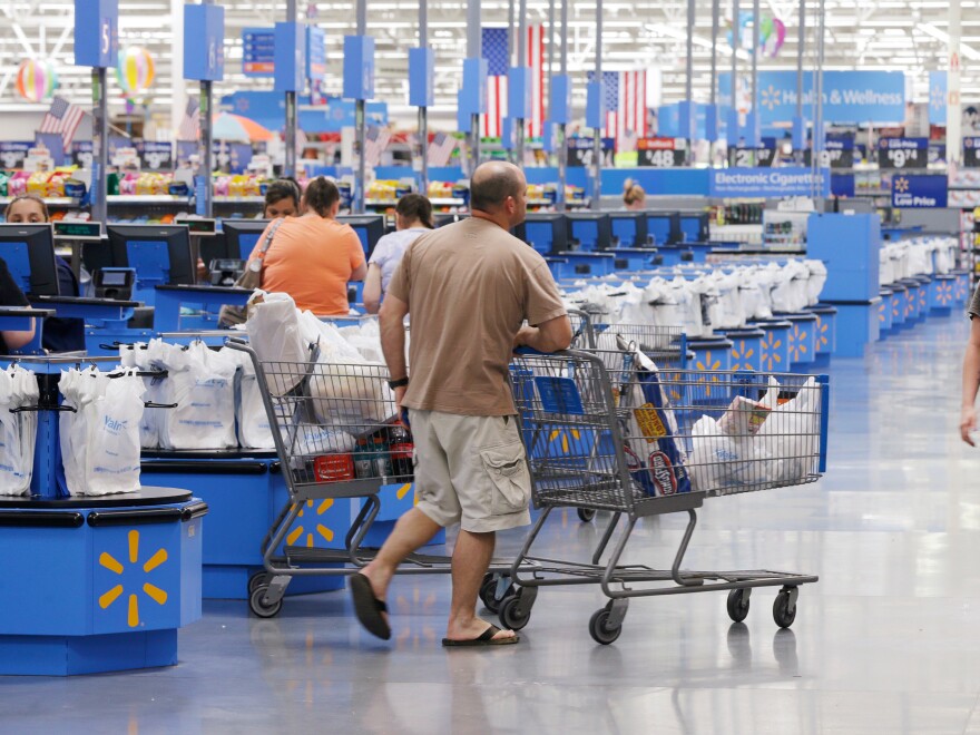 Shoppers walks from the checkout at a Wal-Mart Supercenter store in Springdale, Ark., Thursday, June 4, 2015.