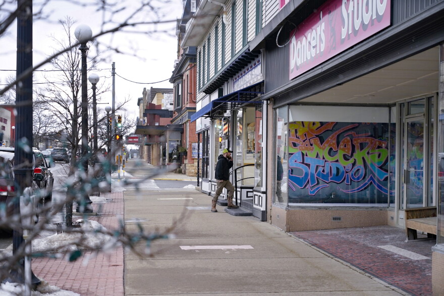 A man talks on his phone as he enters the barber shop along Main Street in Clarion, Pa., Saturday, Feb. 12, 2022. The Democratic Party's brand is so toxic in some parts of rural America that liberals are removing bumper stickers and refusing to acknowledge their party affiliation publicly.
