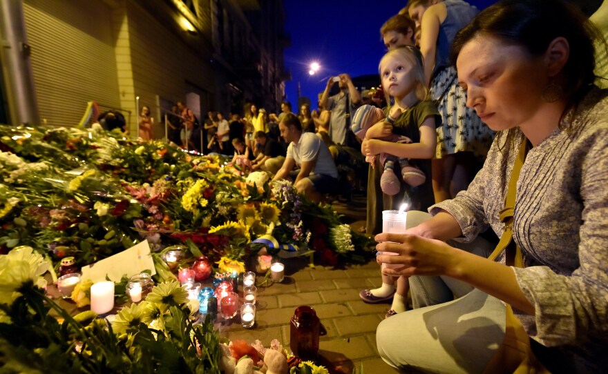 A woman lights a candle in front of the Netherlands Embassy in Kiev, Ukraine, to commemorate those aboard Flight MH17. The flight was on its way from Amsterdam to Kuala Lumpur when it crashed.