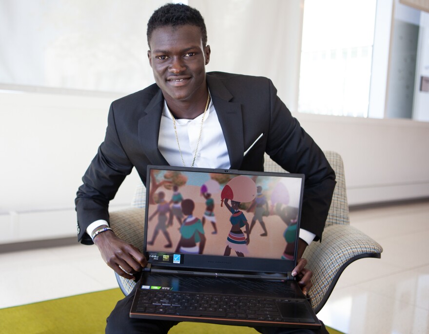 South Sudanese refugee Lual Mayen explains his video game during a visit to NPR.
