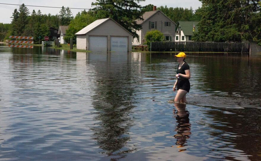 A Cook resident walks through floodwaters on River Street on Friday, June 21, 2024.