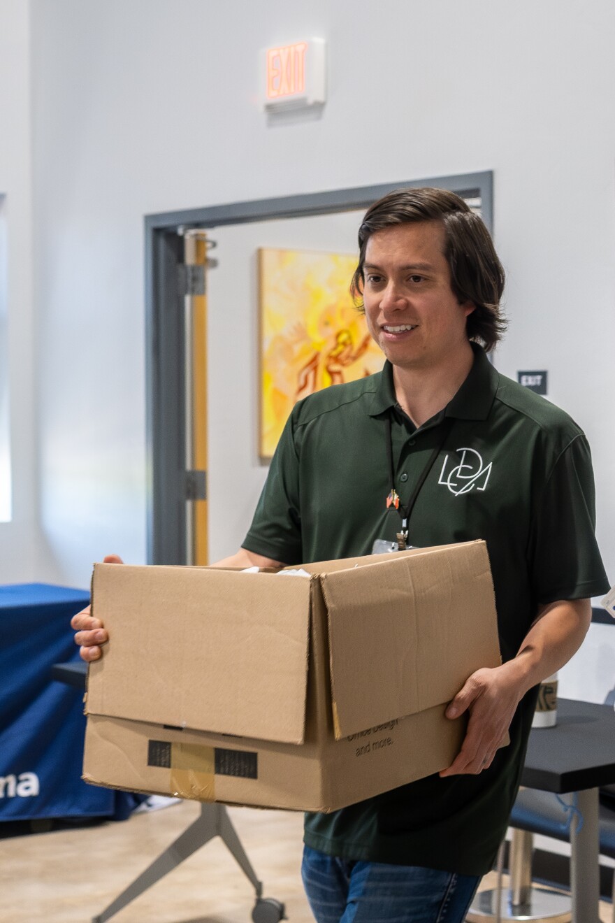 Health Promoter for the Latino Community Development Agency, Benjamin Canizales, carries a box of toothpaste, toothbrushes and other basic oral hygiene items during a health fair on June 6, 2025, at the Mexican Consulate in Oklahoma City. The fair is not solely focused on diabetes awareness, but all aspects of health.