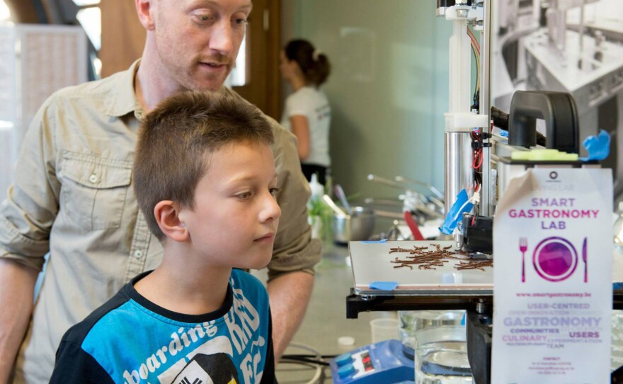 Lab visitors watch a 3-D printer squirt chocolate into an intricate shape designed by chef Arabelle Meirlaen.
