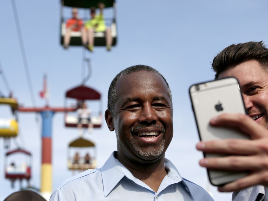 Ben Carson poses for a photo with a fairgoer at the Iowa State Fair in August.