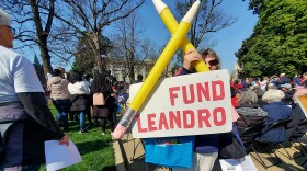 Louise Woods of Charlotte holds pencils and a protest sign near the Aycock monument on Thursday, Feb. 22, 2024, directly across from the North Carolina Supreme Court chambers in Raleigh where the Leandro funding case was being heard. Woods is a former Charlotte Mecklenburg school board member and was one of hundreds protesting near the court chambers.