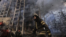 A firefighter walks outside a destroyed apartment building after a bombing in a residential area in Kyiv, Ukraine, Tuesday, March 15, 2022. (Vadim Ghirda/AP)