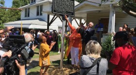 Community members gather in front of John Coltrane's childhood home in East High Point for the unveiling of a Historical Marker in his honor.