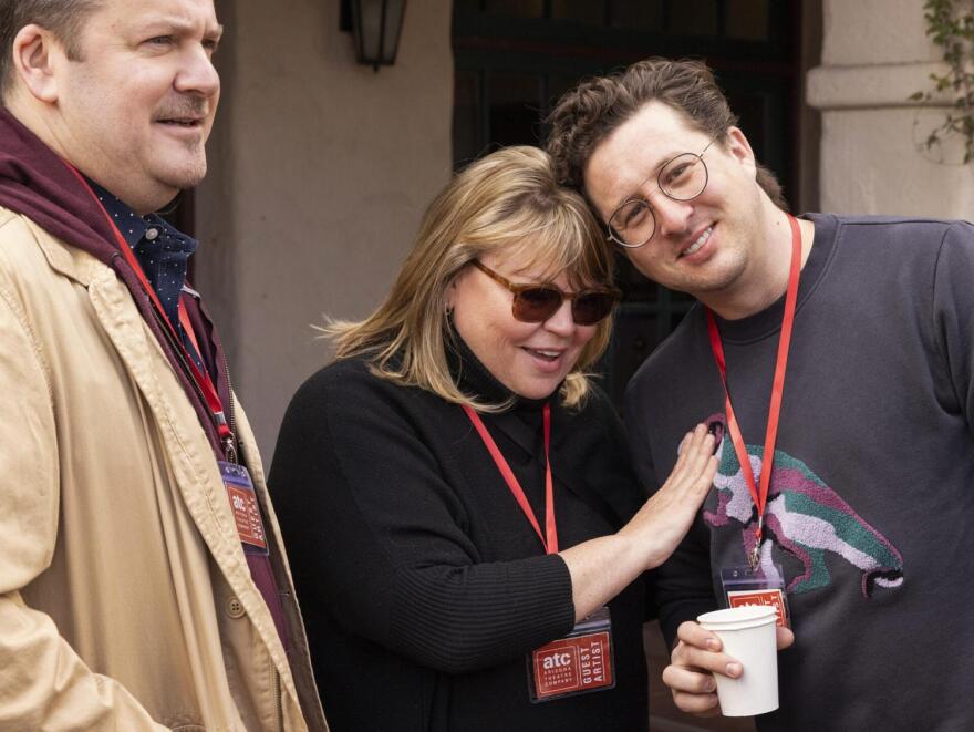 Woman stands in between two men