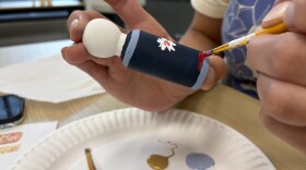 painting a blue wooden doll