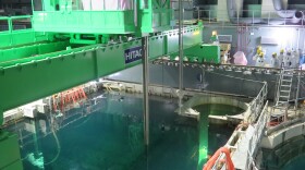 Workers remove nuclear fuel rods from a pool at the Unit 4 reactor of the Fukushima Daii-chi nuclear power plant on Monday.