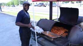 Sedaya Keita-- Joe Hollis placing seasoned ribs and chicken on his grill outside of his restaurant