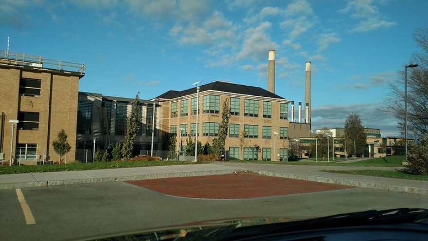 A brick building is positioned next to an empty parking lot