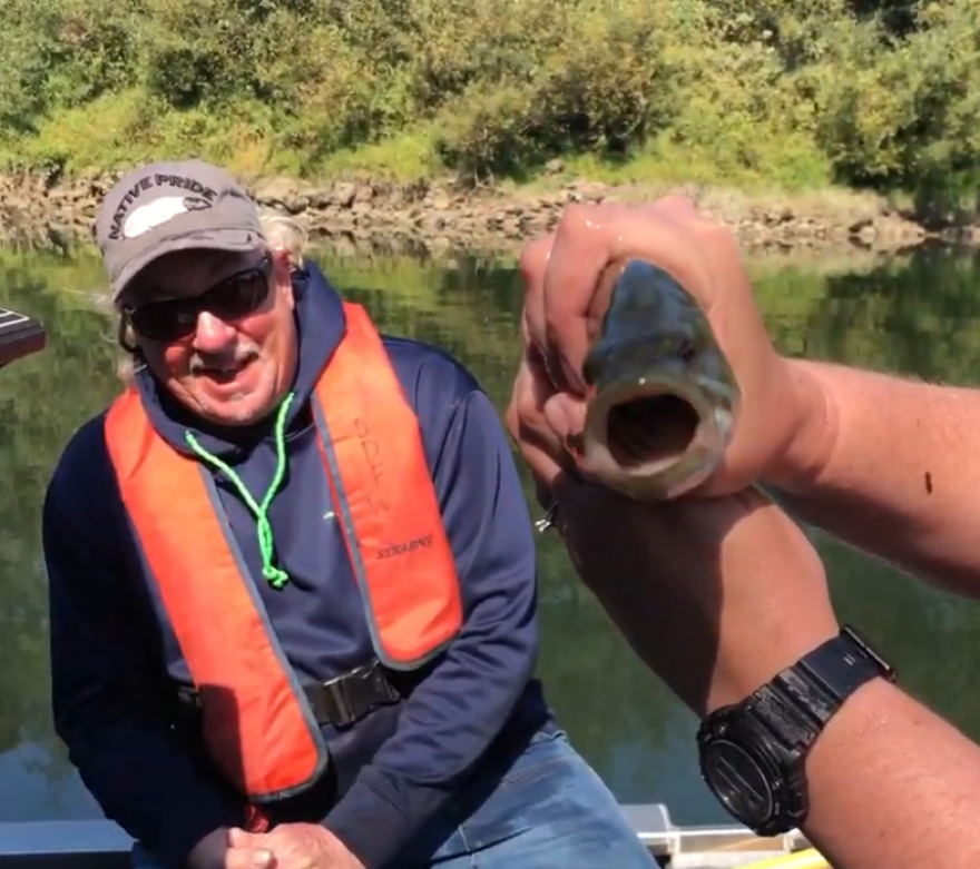 Coquille tribal elder Bill Murphy smiles as Helena Linnell (off camera) holds up a captured bass.