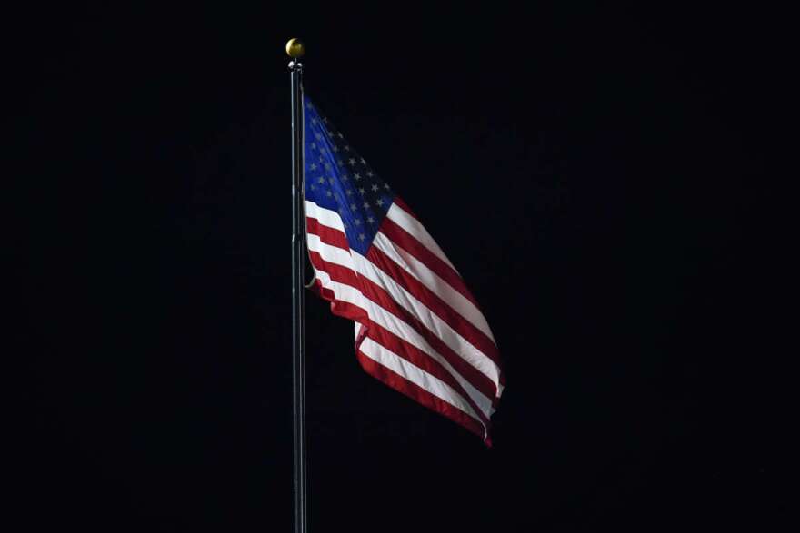 An American flag flies over Comerica Park in the ninth inning of a baseball game between the Detroit Tigers and San Francisco Giants in Detroit, Tuesday, Aug. 23, 2022. (AP Photo/Paul Sancya)