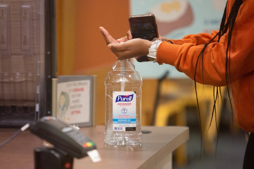 A person uses hand sanitizer.