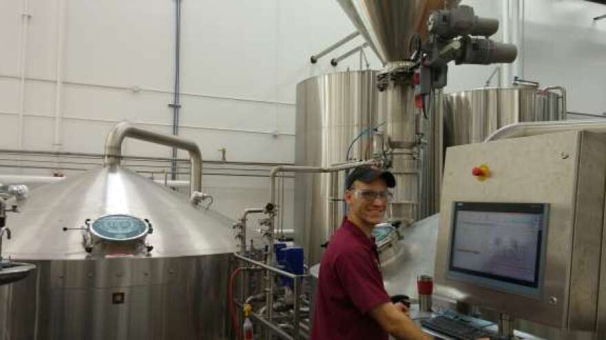 Brew Hub Staff Brewer Andrew Shelton controls two brew tanks while extracting wort to brew beer. 