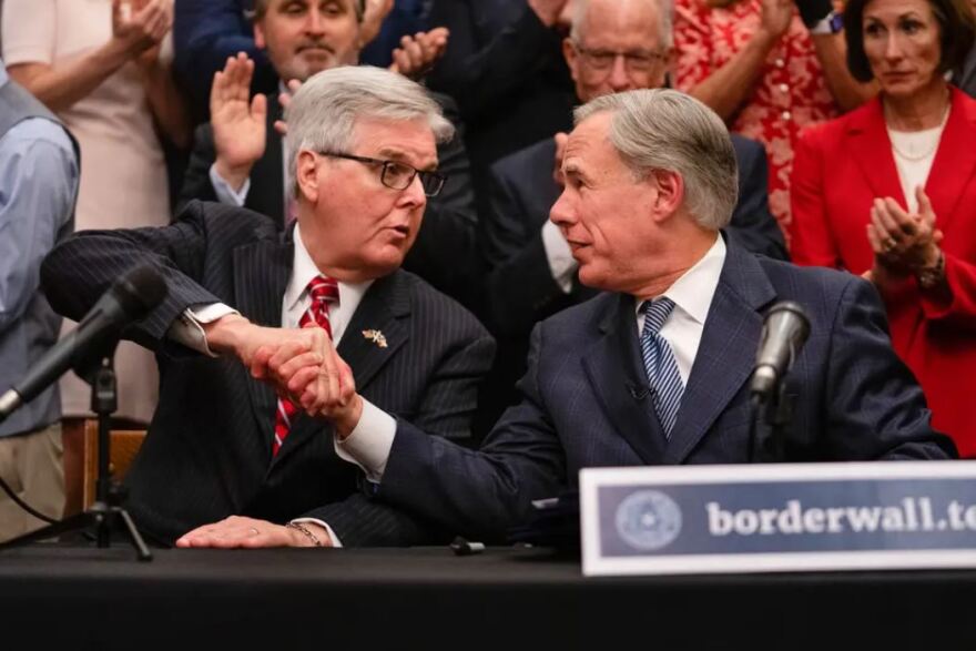 Lt. Gov. Dan Patrick, left, and Gov. Greg Abbott shake hands after a press conference.