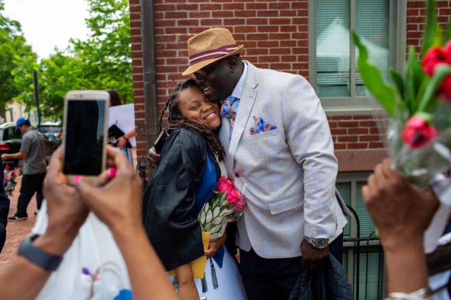 Rashema Melson gets a hug and has her photo taken with her cousin Anthony Young after the 2019 Georgetown University graduation ceremony. [Robb Hill for The Washington Post / Getty Images]