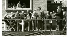 Maurice Hubbard, master of ceremonies for the corner stone laying, on May 7, 1951. The copper box is on the right side of the table. Johnson County government officials sit on the temporary wooden stage.