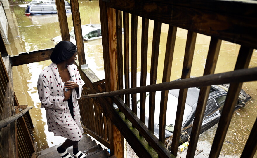 Glad that her brother left early for work, Shakera James, 22, looks over damage to flooded cars caused by heavy rain in her apartment parking lot near South Whitney Street and Warrenton Avenue near the Hartford-West Hartford town line on Aug. 19, 2021.