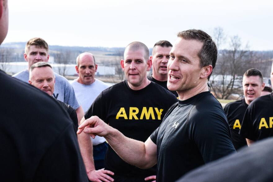 Former Gov. Eric Greitens speaks with Army members.