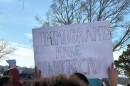 A student holds up a sign that says "Immigrants Make America" during a walkout protest against ICE in Derby.