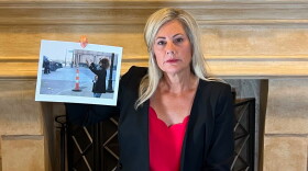 Kathleen Garber in her office holding up a picture of a protestor in downtown Columbus from May 2020.
