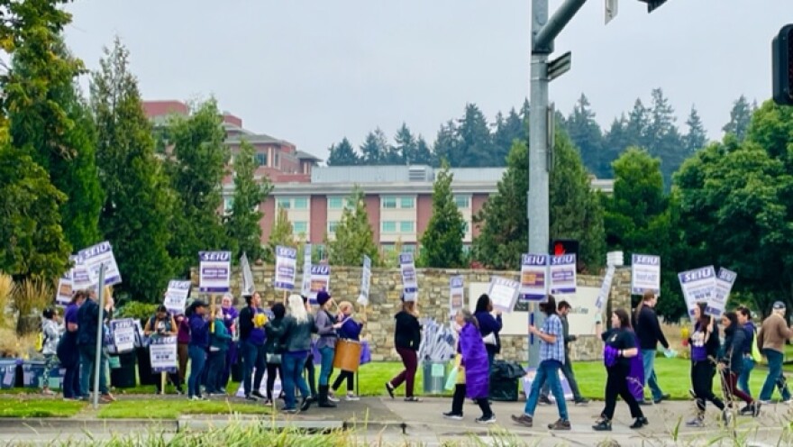 Union healthcare workers take over the sidewalk outside PeaceHealth RiverBend Medical Center Tuesday to rally for better staffing, pay and COVID protections. This was not a work stoppage. Picketers marched during work breaks.