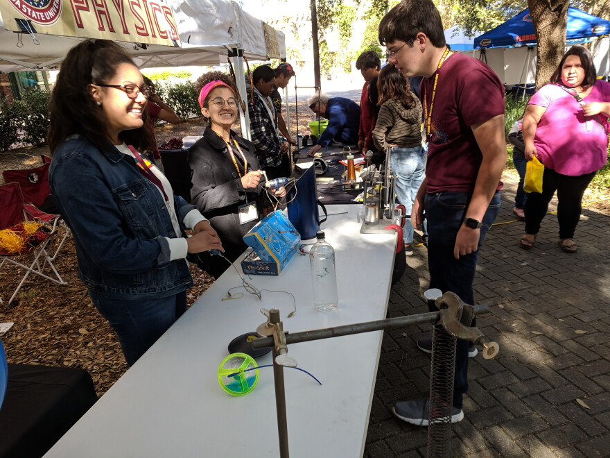 Science Festival visitors checking out the Florida State University Physics Department booth.