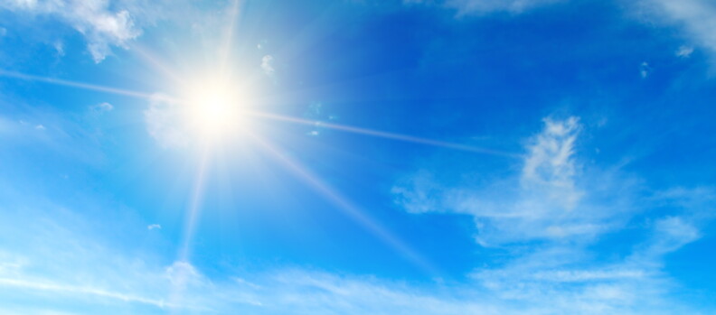 Clouds in the blue sky. Bright midday sun illuminates the space.