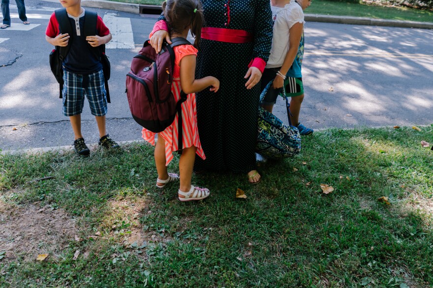 Ghada greets her children at the bus stop.