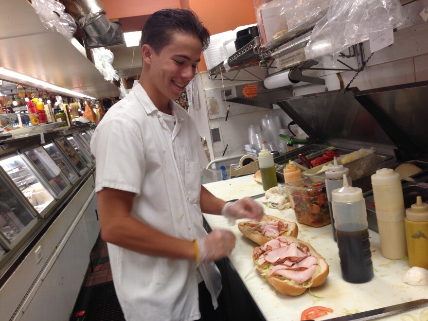 Nick Frigo makes a sandwich behind the counter at Frigo's, an Italian deli in Springfield, Massachusetts.