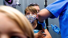 Finn Washburn, 9, receives an injection of the Pfizer-BioNTech COVID-19 vaccine in San Jose, Calif., on Wednesday, Nov. 3, 2021, as his sister, Piper Washburn, 6, waits her turn.