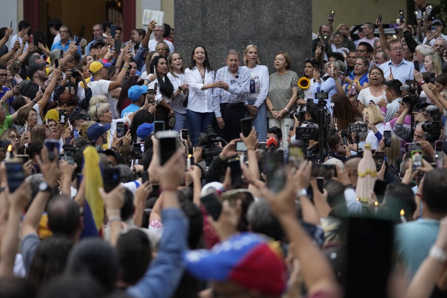 Venezuelan opposition candidate Edmundo Gonzalez (center right) and opposition leader Maria Corina Machado (center left) greet a sea of supporters at a campaign event in Caracas on Sunday, July 21, 2024.