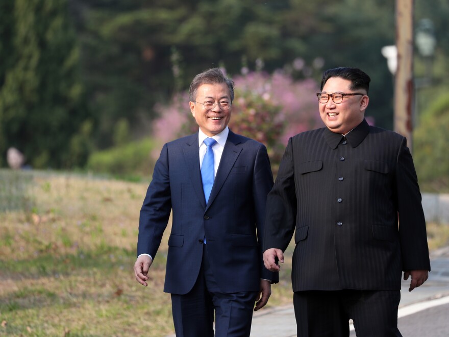 Moon and Kim walk together after a tree-planting ceremony at the truce village of Panmunjom on Friday.