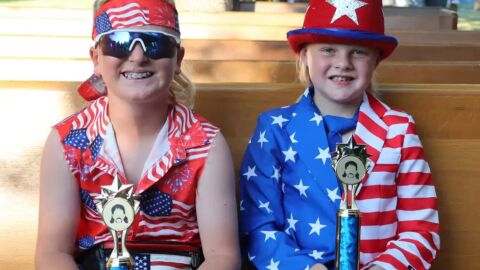 Reed Moszer (left) and Paul Maier hold up the trophies they won at the mullet pageant at the Clay County Fair in Barnesville on July 9 | MPR News