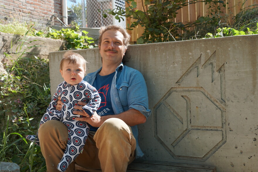 Stuart Keating sits with his son Merlin on Earthbound Beer’s patio. He’s hoping to keep the brewery going through the end of the year, but he’s unsure how much longer it will last without financial relief.