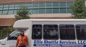 Henry Ellis poses in front of his shuttle bus outside of UF Health Shands Hospital. Ellis and his late wife started the company in 2017. (Timothy Wang/WUFT News)