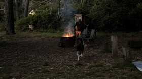 A camper at a State Park stokes a fire.