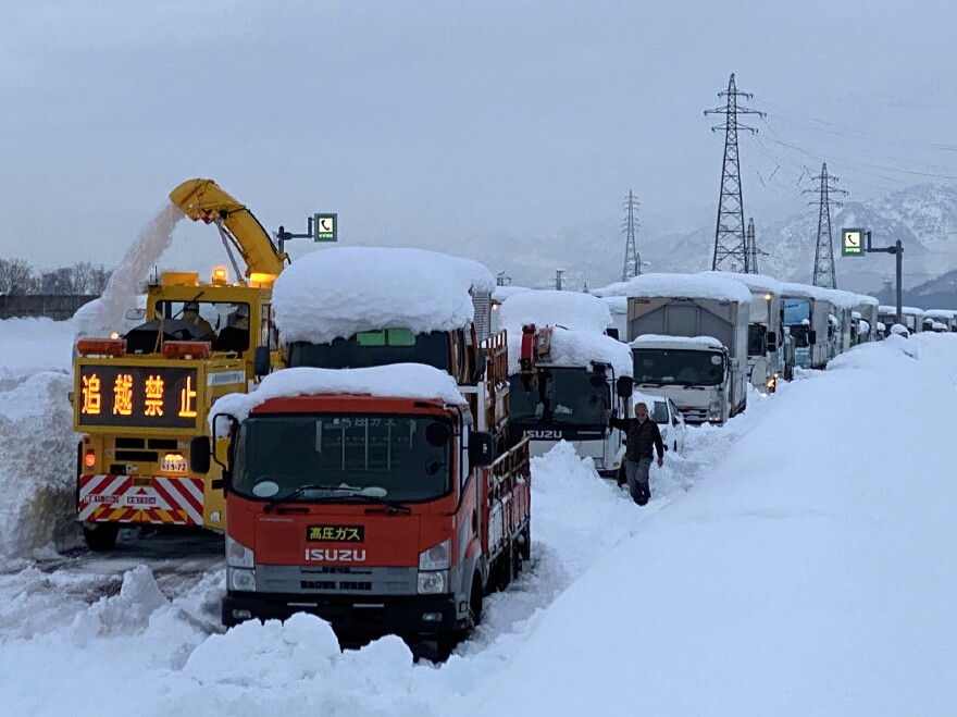 A snowplow clears a path beside cars stranded on the snow-covered Kan-etsu Expressway at the city of Minamiuonuma in Japan's Niigata Prefecture on Friday.