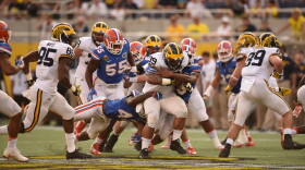A swarm of Florida defenders try and bring down Michigan full back Sione Houma (39) in the second half. (Greenberry Taylor/WUFT News)