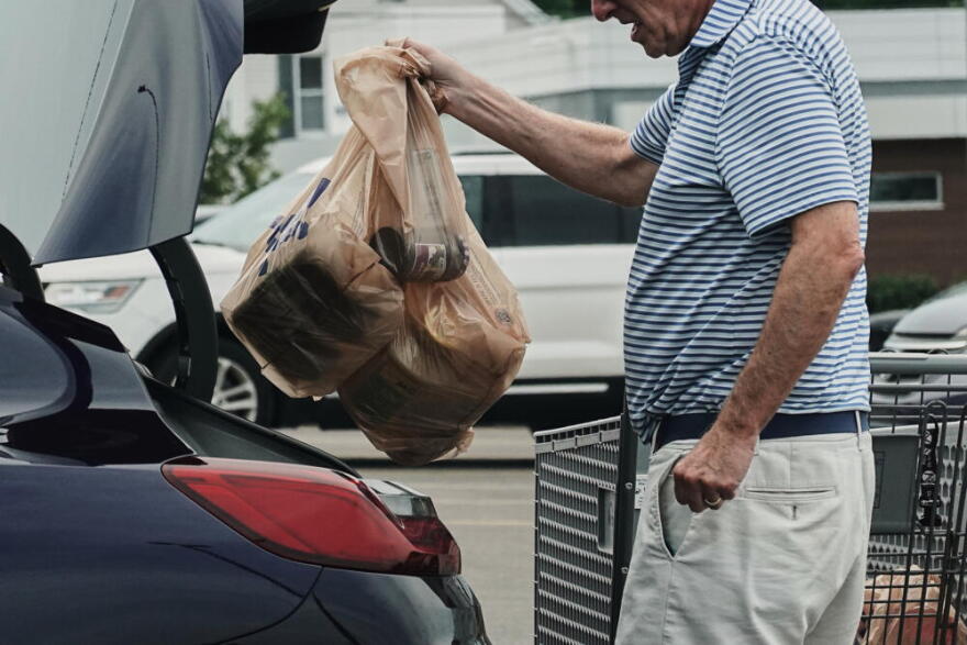 A person loads groceries in plastic bags into their vehicle, May 18, 2026, at a grocery store in Cincinnati. (Joshua A. Bickel/AP)