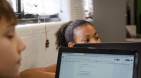 A fifth grade student works with her classmates on a project about food insecurity at Ritenour School District's gifted learning center Wednesday.