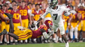 Oregon wide receiver Evan Stewart is shown on his feet breaking a tackle by a USC player.