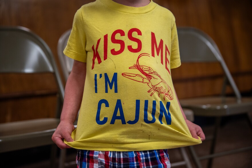 One of the Chauvin Schools Reconnect's youngest attendees poses with his yellow shirt stretched out during the event on April 27, 2024. It reads, "Kiss me, I'm Cajun."