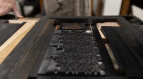 Gary Gregory at Haverhill’s Museum of Printing demonstrates the printing process with a replica of 18th-century press. Metal blocks of type like these were dabbed with ink then pressed onto paper to print early American newspapers.