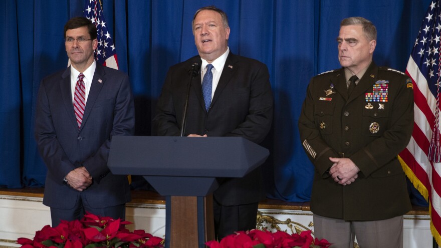 Secretary of Defense Mark Esper, left, and Chairman of the Joint Chiefs of Staff Gen. Mark Milley, right, listen as Secretary of State Mike Pompeo delivers a statement on Iraq and Syria, at President Trump's Mar-a-Lago property, Sunday, Dec. 29, 2019.