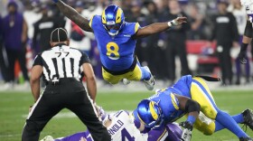 Minnesota Vikings quarterback Sam Darnold (14) is sacked by Los Angeles Rams defensive tackle Kobie Turner (91) as Jared Verse (8) dives on during the first half of an NFL wild card playoff football game, Monday, Jan. 13, 2025, in Glendale, Ariz. (AP Photo/Ross D. Franklin)