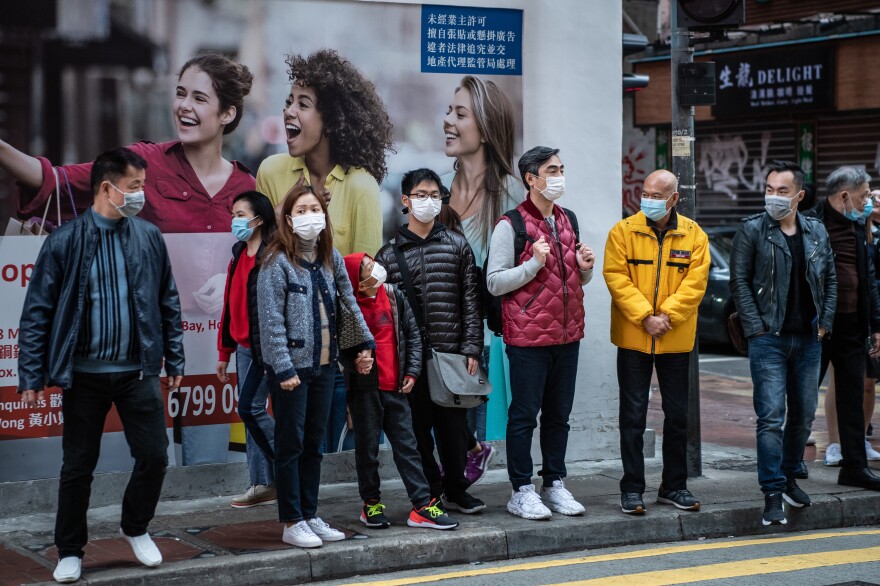 For societies that were affected by the SARS epidemic, the widespread usage of masks was more quickly adopted during the spread of COVID-19. Photograph of people waiting to cross the street in the Causeway Bay neighborhood of Hong Kong, Monday, January 27, 2020.