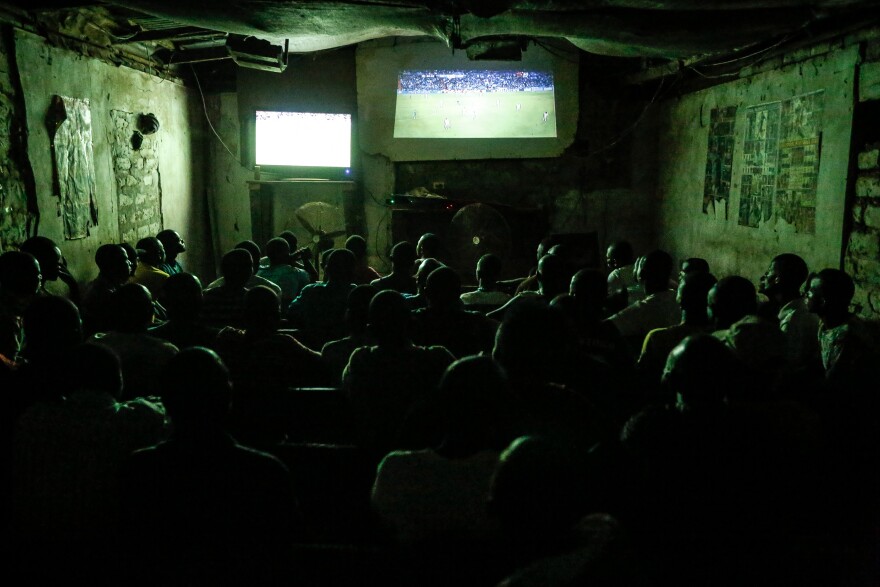 Young men, and the occasional woman, squeeze into Justina's video club in Ganta to watch soccer.